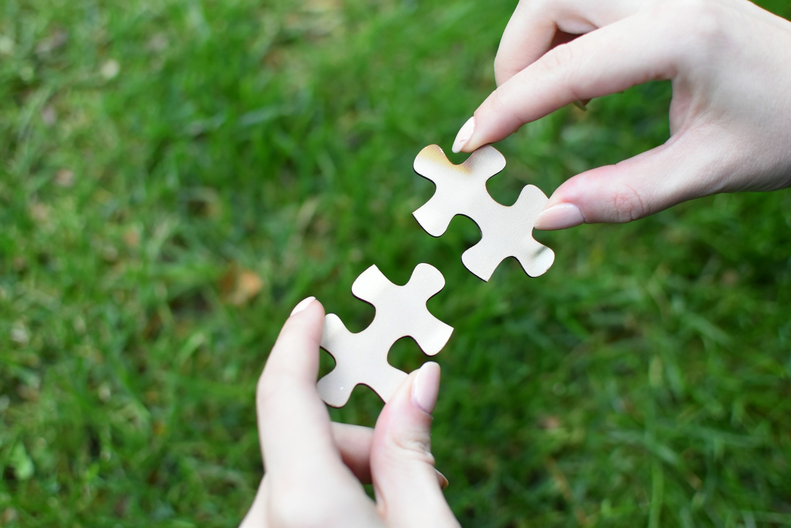 Two hands bringing matching jigsaw pieces together