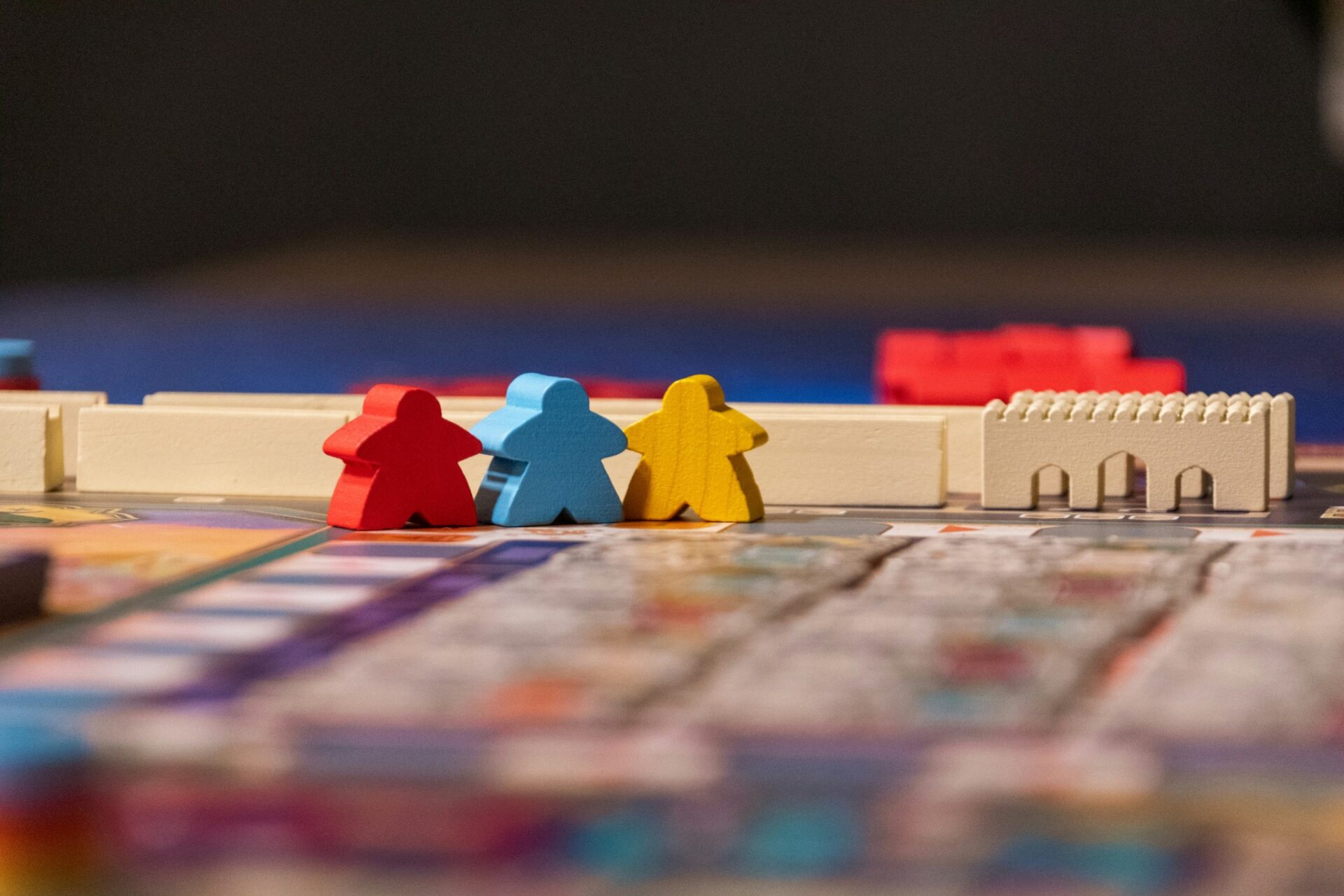 Red, blue and yellow wooden playing pieces on a board game