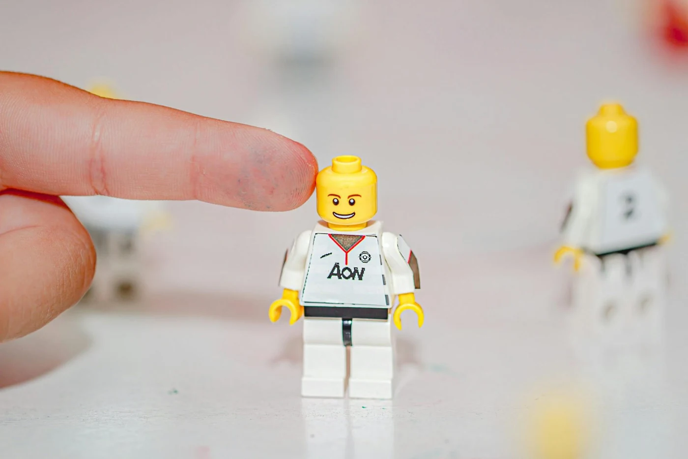 A finger pointing at a LEGO figure
